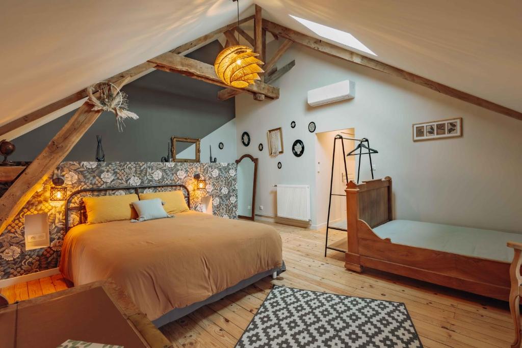 a bedroom with a large bed in a attic at Au Pressoir de Boisy in Pouilly-les-Nonains