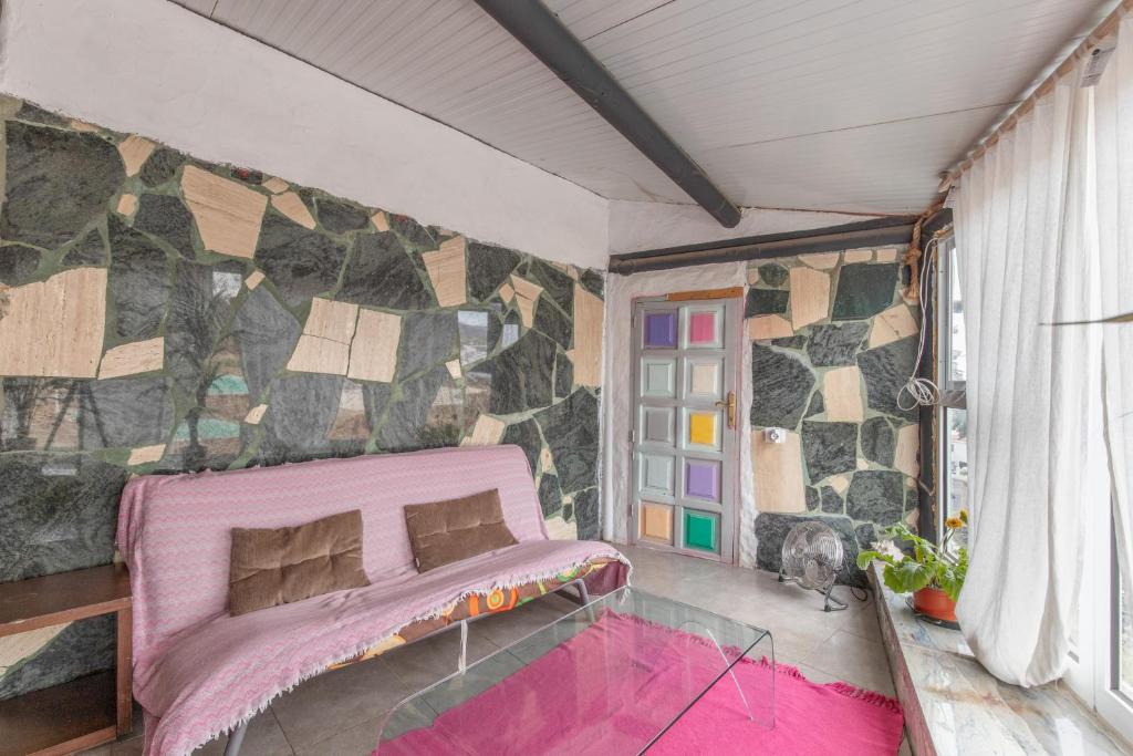 a bedroom with a pink bed and a stone wall at Oaxaca Venado in Agaete