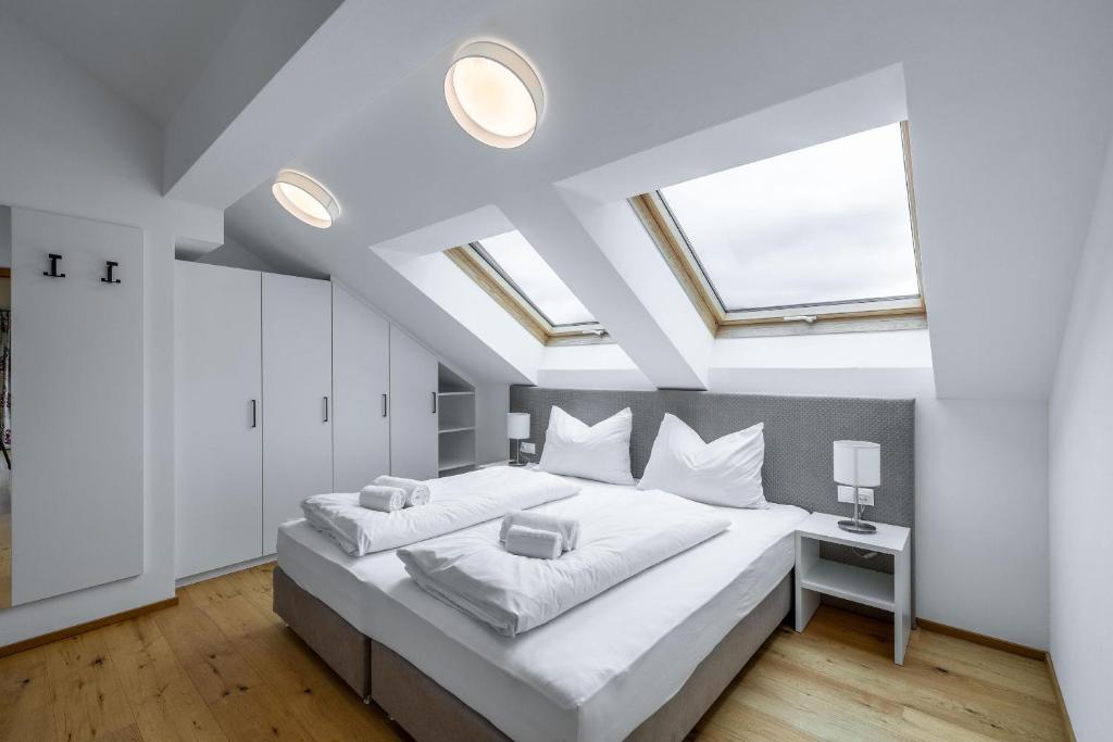a bedroom with a large white bed with skylights at Schwarzhans Appartments in Bludenz