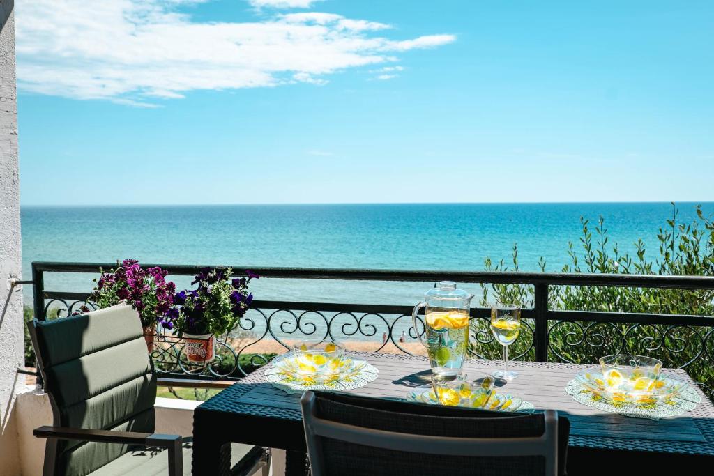 a table with a view of the ocean on a balcony at Corfu Glyfada Beach Apartment 25 in Glyfada