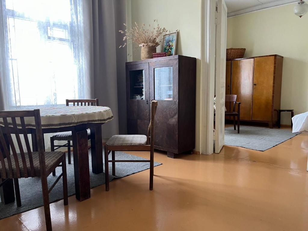 a dining room with a table and a cabinet at Vekšin Old Town & Promenade Apartment, Haapsalu in Haapsalu