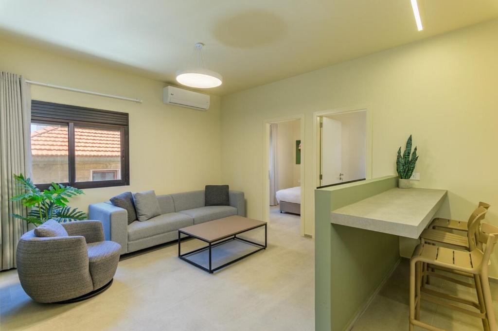 a living room with a couch and a table at Capri 2-BR Apartment In Bahsa Batroun in Batroûn