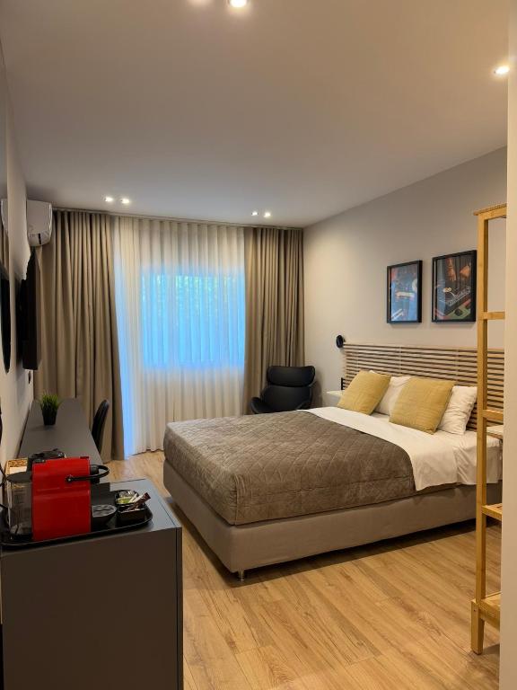 a bedroom with a large bed and a desk at Luxor Suites Olimpou in Thessaloniki