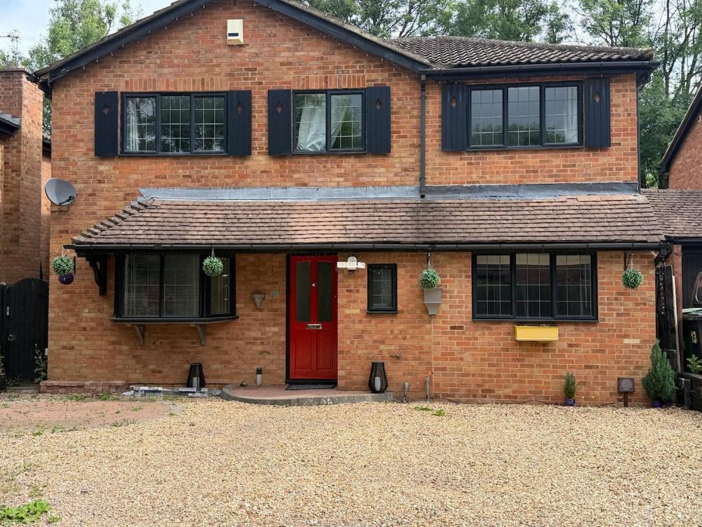 a brick house with a red door at Spacious 5-Bed Entire Home in Sherborne Saint John