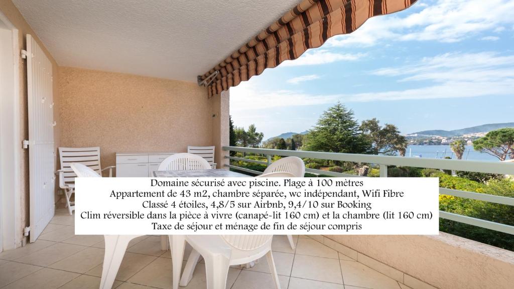 a balcony with a table and chairs and a large window at Bel appartement vue mer in Agay - Saint Raphael