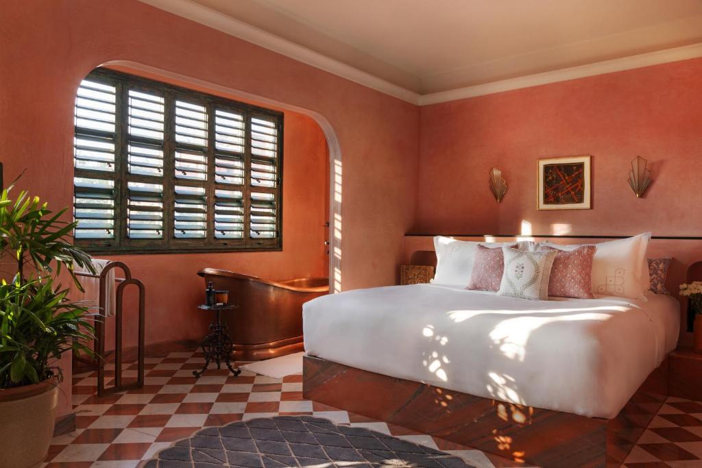 ein Schlafzimmer mit einem großen Bett und einem Fenster in der Unterkunft Abode Jaipur in Jaipur