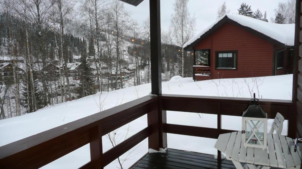 a balcony with a view of a snow covered forest at Lomaniini in Tahkovuori
