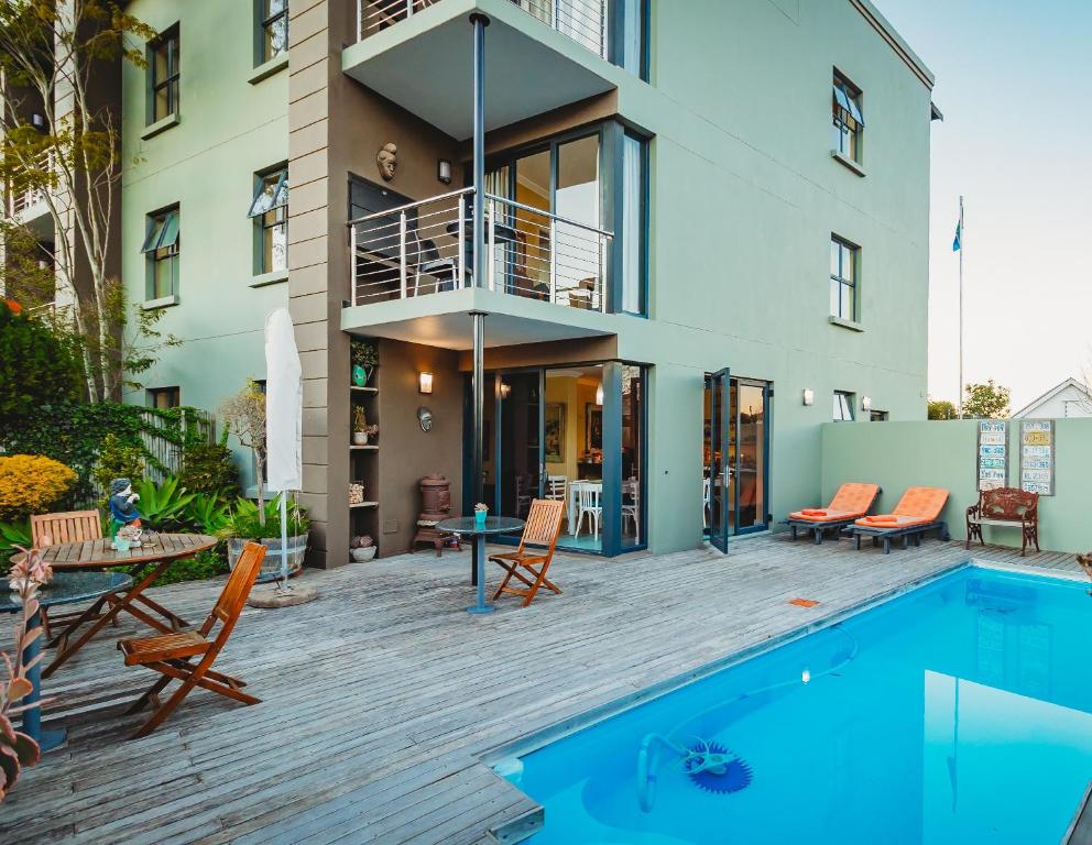 a house with a swimming pool next to a building at 17onWellington Apartments in George
