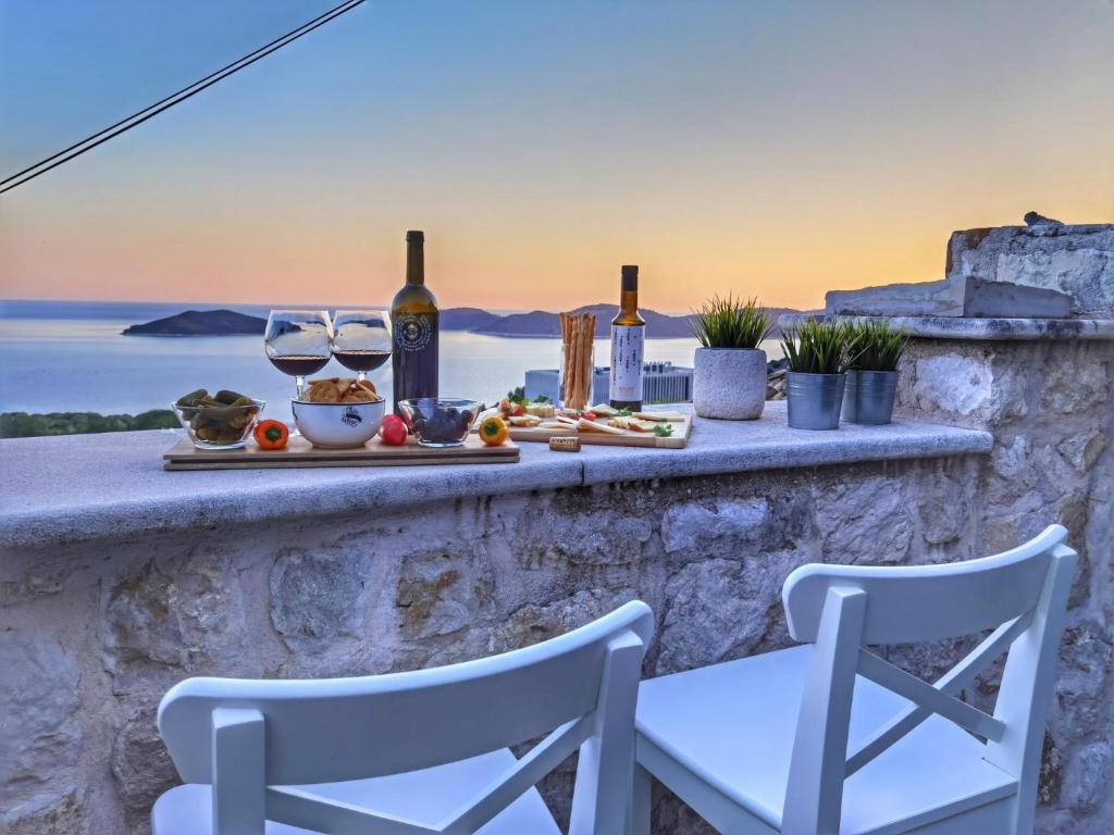 a table with two chairs and wine glasses on a wall at Villa Dalmata in Brsečine