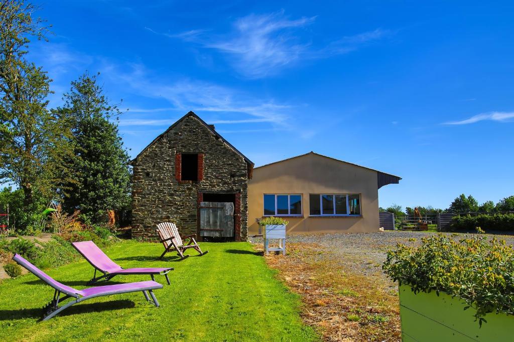 a house with two lawn chairs in front of it at Studio Le Jardin in Lison
