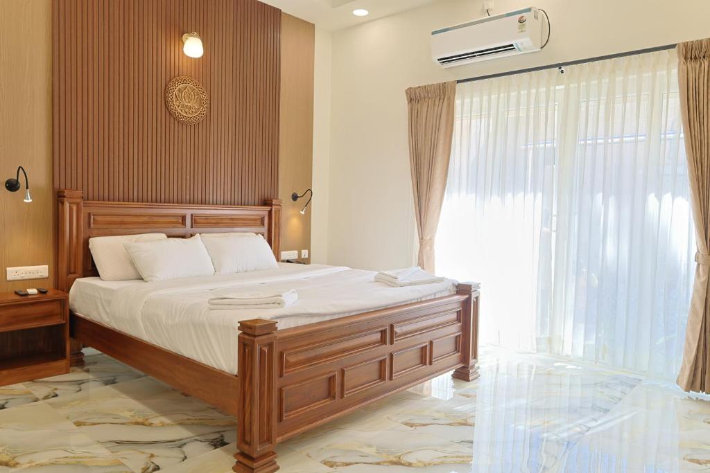 a bedroom with a bed and a large window at MHOMES Resort - Madurai in Alagar Kovil