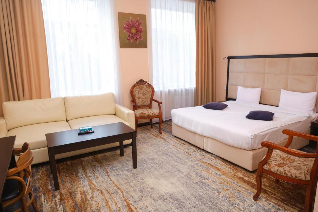 a hotel room with a bed and a couch at Vanadzor Armenia Health Resort & Hotel in Vanadzor