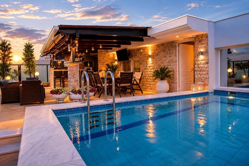 a swimming pool in front of a house at Luxury Penthouse with private pool in Preveza