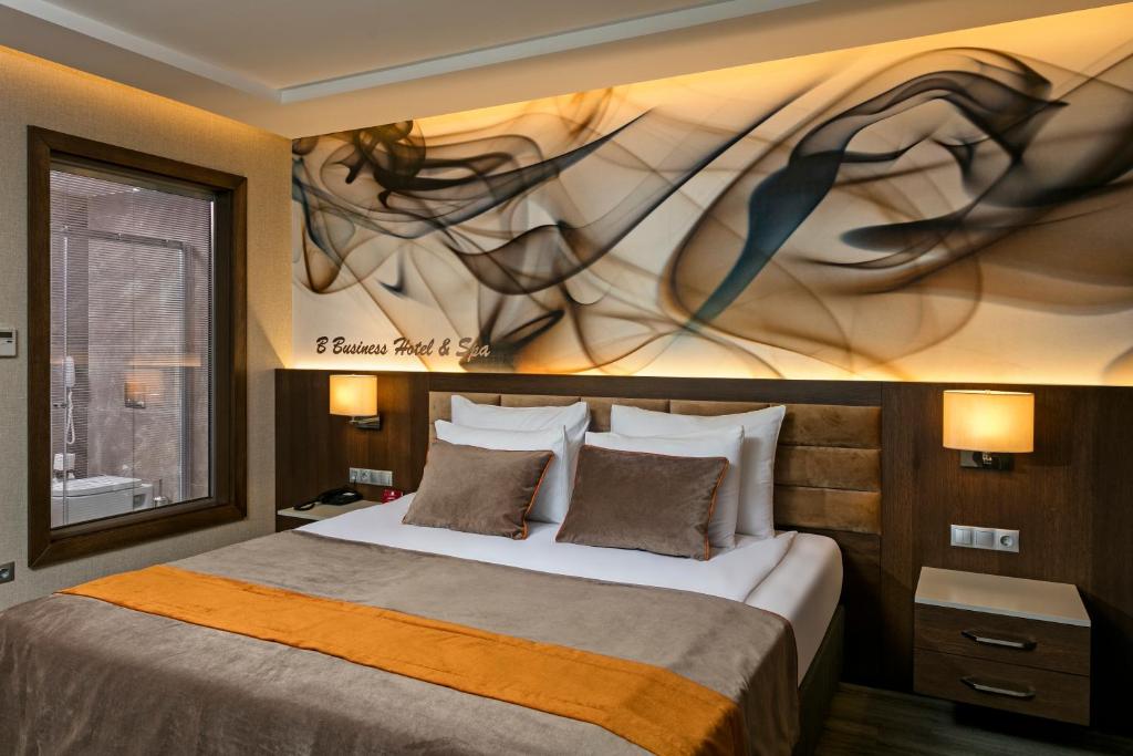 ein Schlafzimmer mit einem Bett und einem Gemälde an der Wand in der Unterkunft B Business Hotel & Spa in Antalya