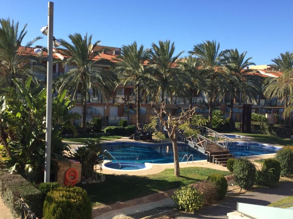 a view of a resort with a swimming pool and palm trees at Apartamento Port Marino in Cambrils