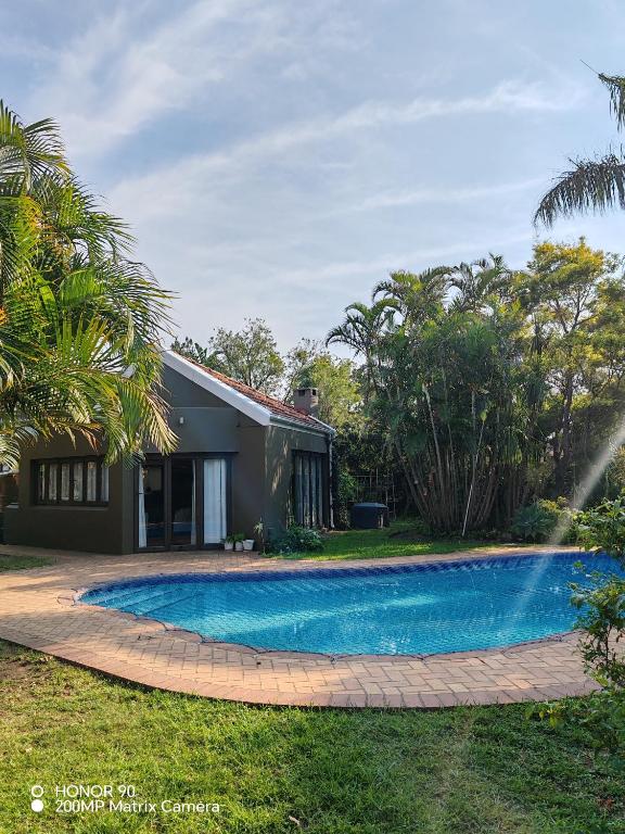 a swimming pool in front of a house at Cozy Cork Cottage - Sleeps 4 in Beacon Bay