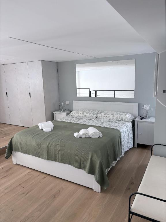 a bedroom with a large bed with two towels on it at Monica's Loft in Domodossola