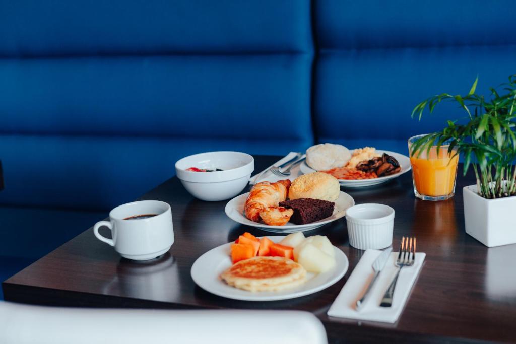 A breakfast table with coffee, pastries, fruit and hot dishes.