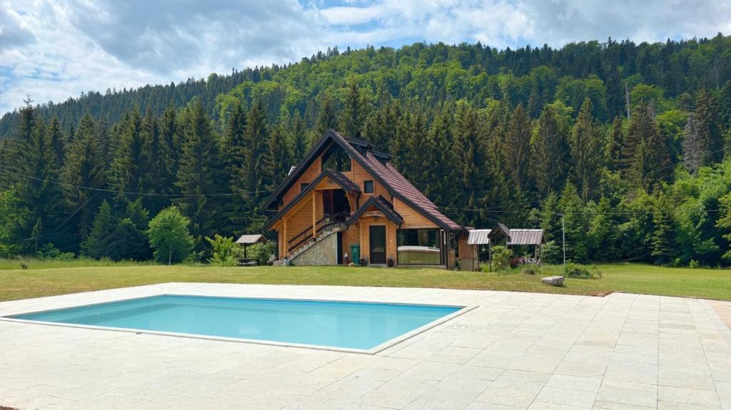 a house and a swimming pool in front of a house at Brvnara Miris Bora - sa bazenom - in Šljivovica