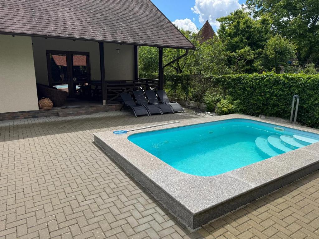 a swimming pool with chairs and a house at Загородный дом в Пырыта in Vadul lui Vodă