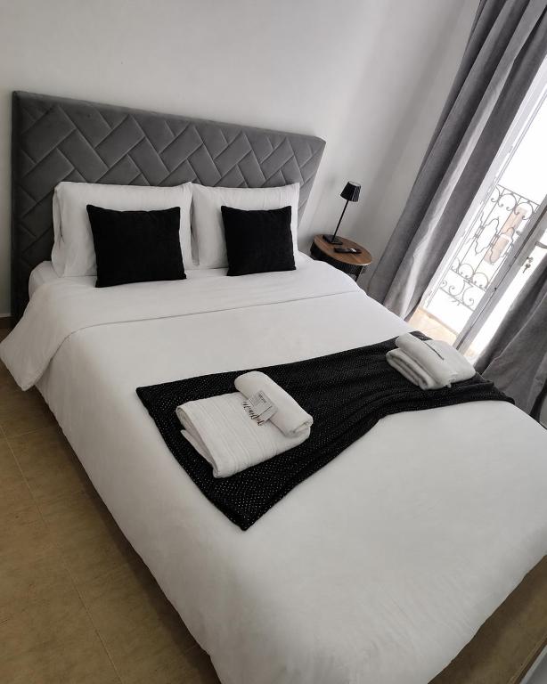 a large white bed with two towels on it at AL-Andalus in Elvas