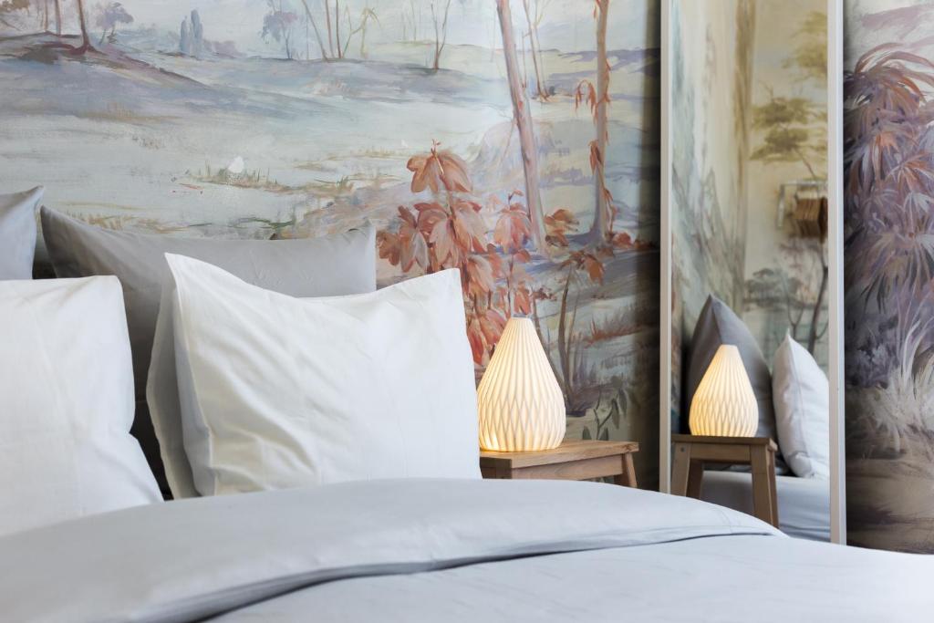 a bed with white pillows and a painting on the wall at House Sao Bento in Lisbon