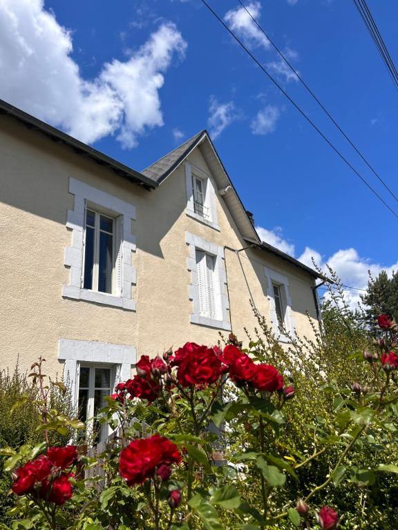 a house with red roses in front of it at La chambre magique in Masseret
