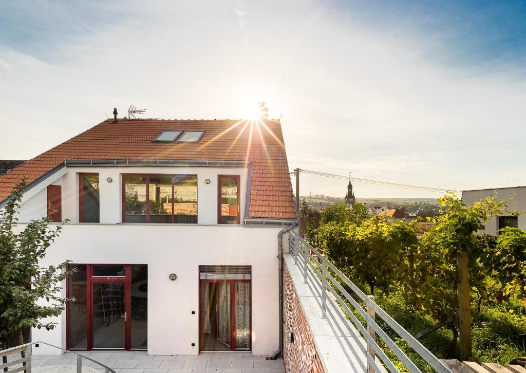 une maison blanche avec des portes rouges et un toit dans l'établissement Apartmány Vinařství Václav, à Hustopeče