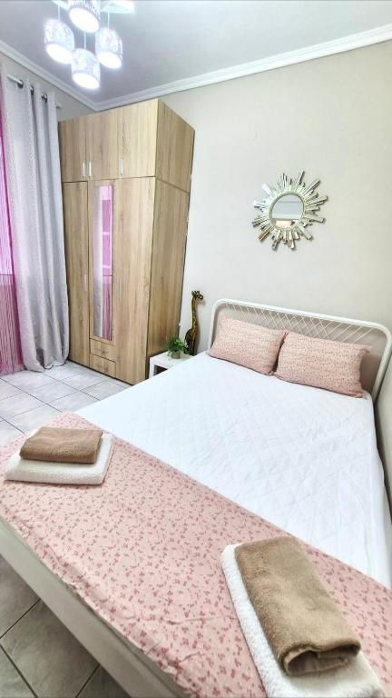 a bedroom with a large white bed with pink pillows at Apartman Malvina in Flogita