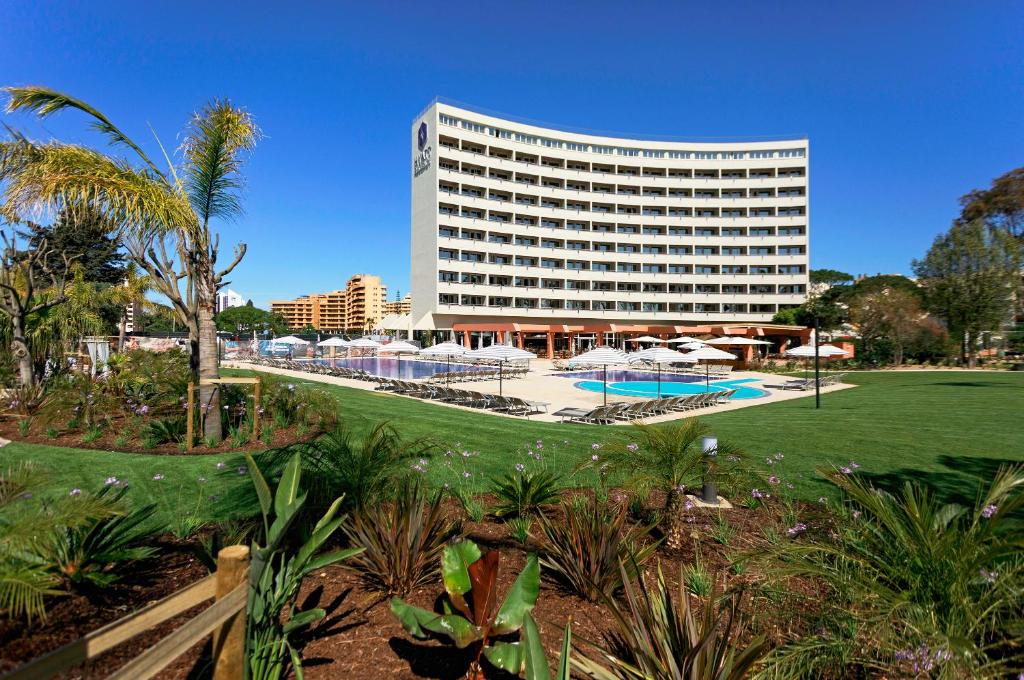 a large white building with a pool in front of it at Hyatt Regency Vilamoura Algarve in Vilamoura
