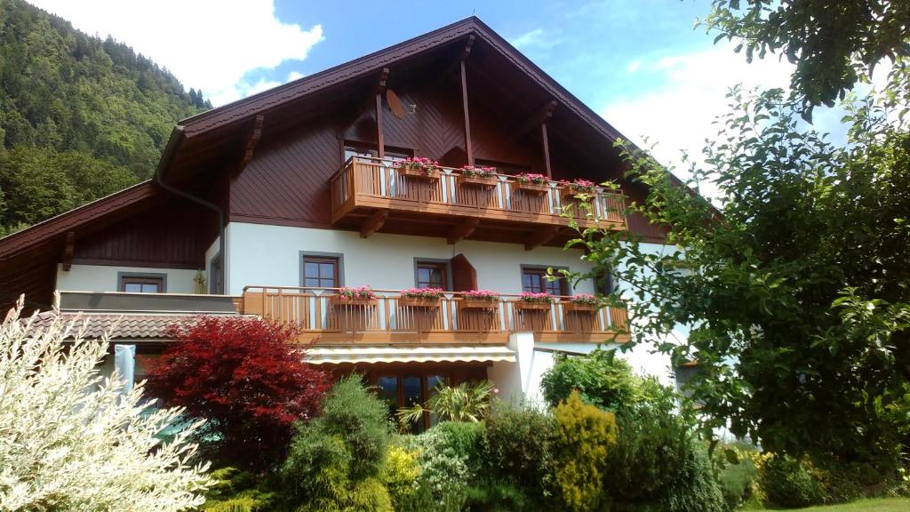 un edificio con balcone con fiori rossi di Landhaus Gailer a Treffen