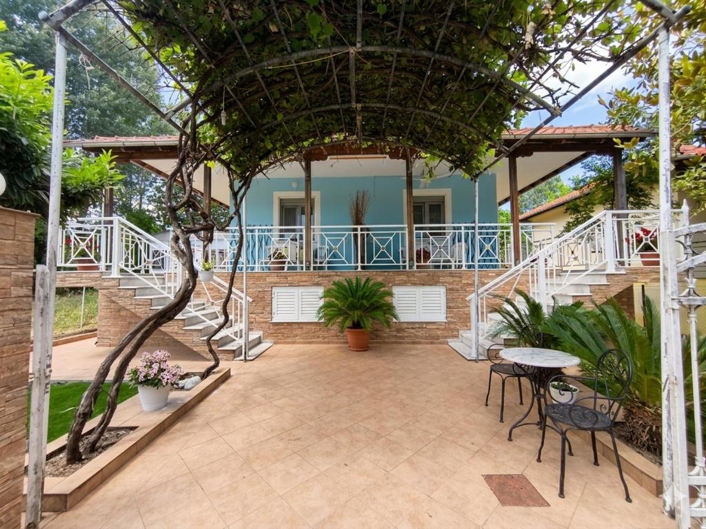 a patio with a table and chairs and stairs at Don Bazilio Brace in Leptokarya