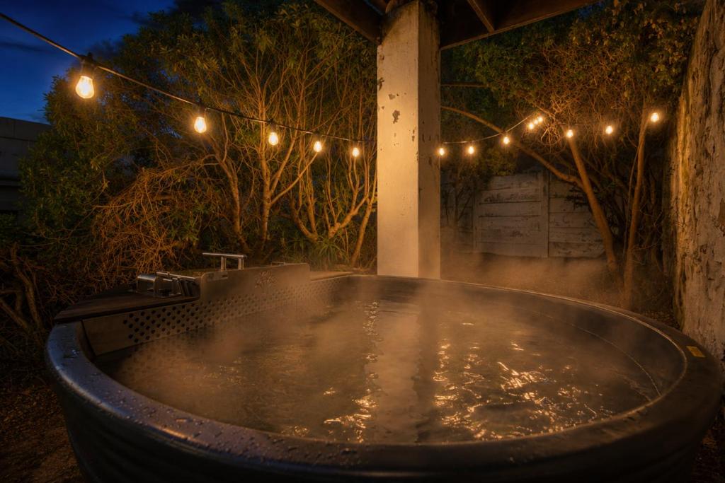 a jacuzzi tub with lights in a yard at The Barn Main House in Arniston