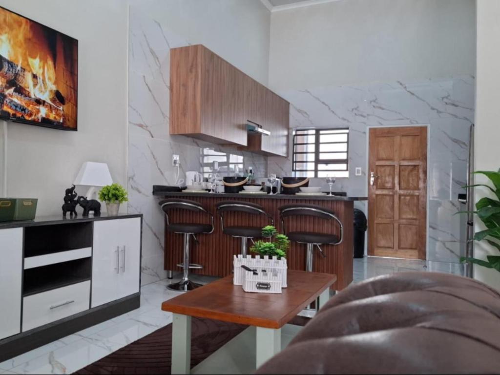 a kitchen with wooden cabinets and a wooden table at Ficus self catering in Burgersfort