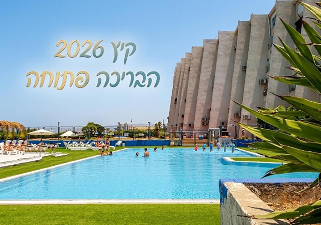 a large swimming pool in front of a building at Nahariya SEA VIEW, Ha-aliya in Nahariyya