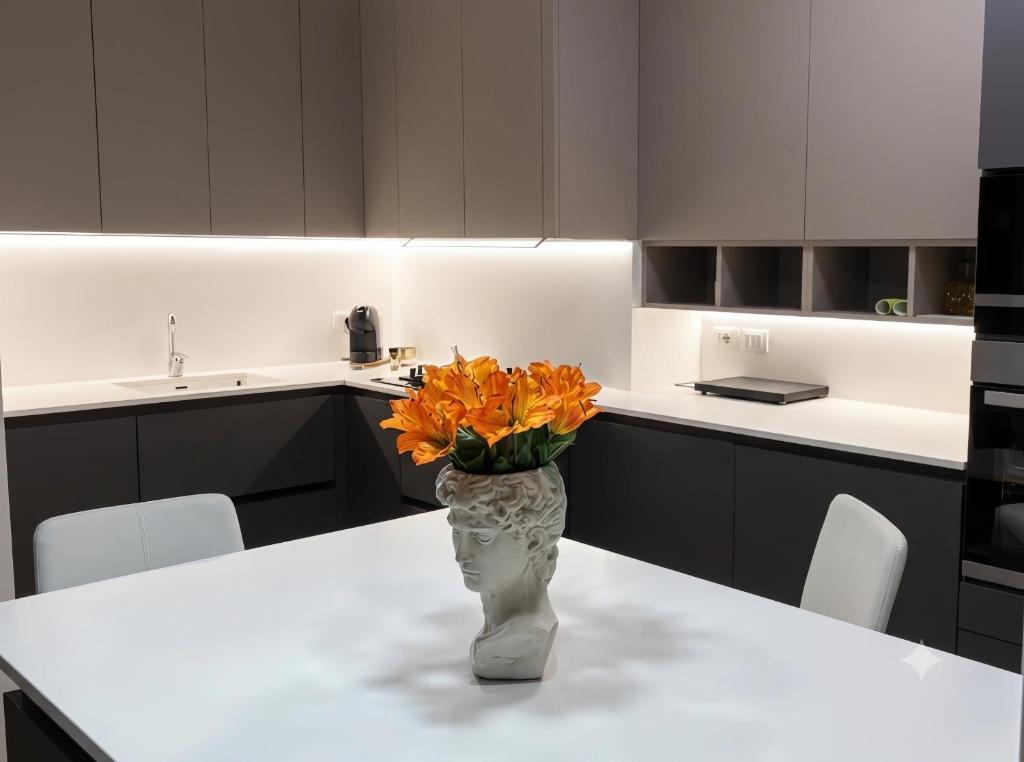 a vase with orange flowers sitting on a table in a kitchen at The Desdemona in Pordenone