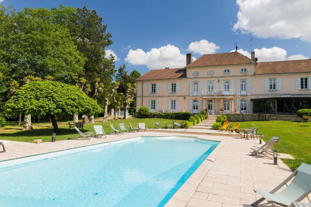 a large house with a swimming pool in front of a house at Château Du Mont Joly in Sampans