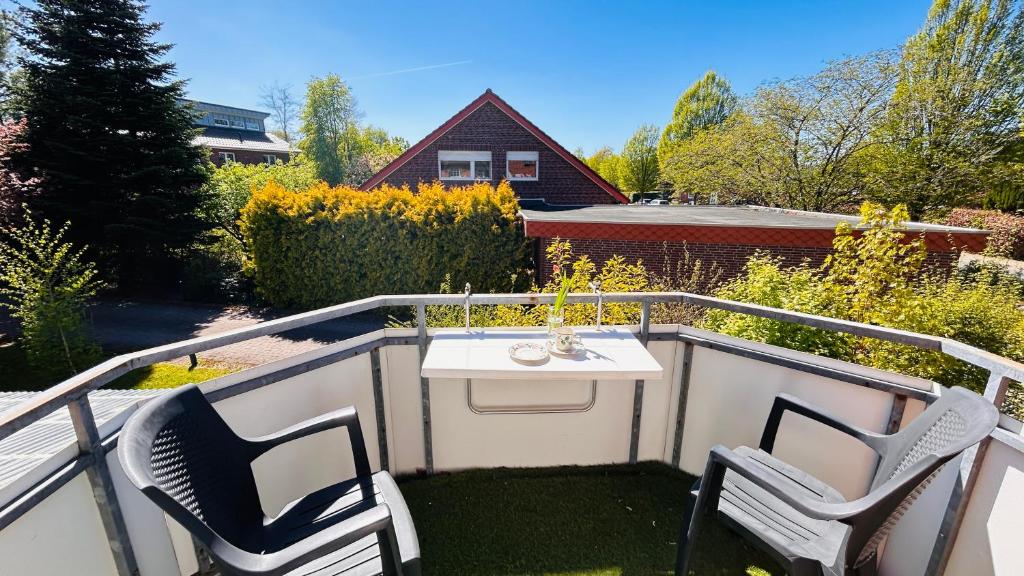 ein Balkon mit zwei Stühlen und einem Tisch darauf in der Unterkunft Staytopus Pension - Heidepark, Kartbahn, Sauna ink, Garden, BBQ in Schneverdingen