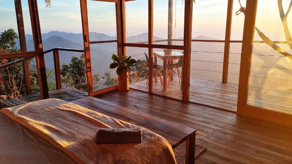 a bedroom with a bed and a view of the mountains at Minca Sintropia - Sustainable Lodge & Organic Coffee Finca in Minca