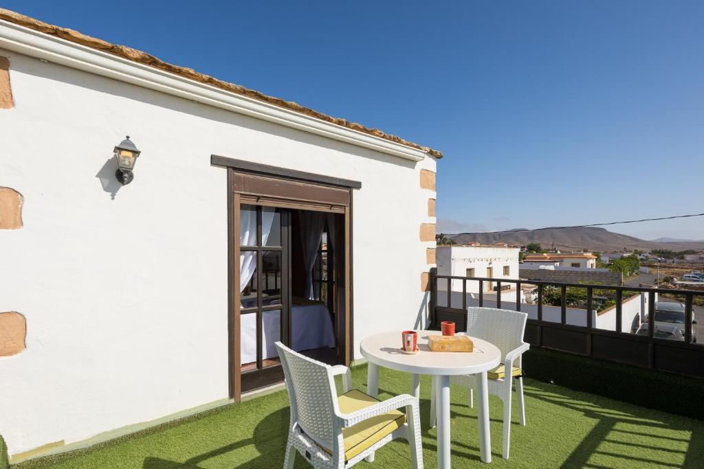 a patio with a table and chairs on a balcony at Home2Book La Molina A, Cozy Terrace Retreat in Triquivijate