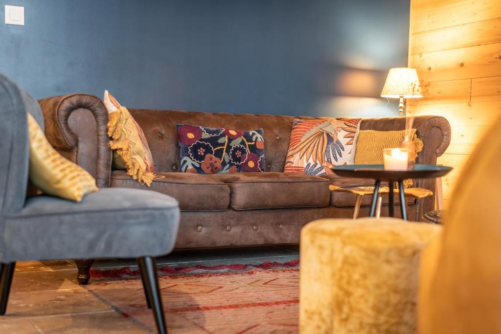 a living room with a brown couch and a table at chalet 1 - les jolis chalets in Barbey-Séroux