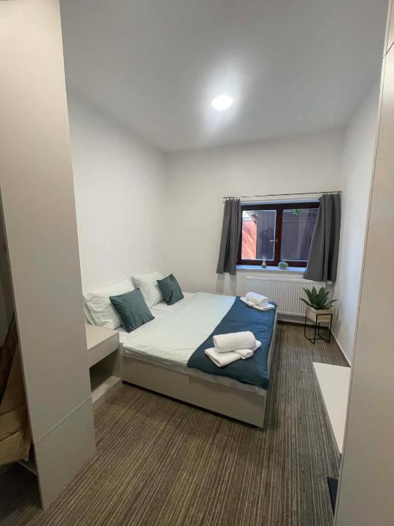 a small bedroom with a bed and a window at Hotel u Freuda Příbor in Nový Jičín