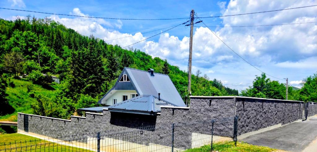 a house with a roof on top of a stone wall at My sweet home Vrhpraca Jahorina in Jahorina