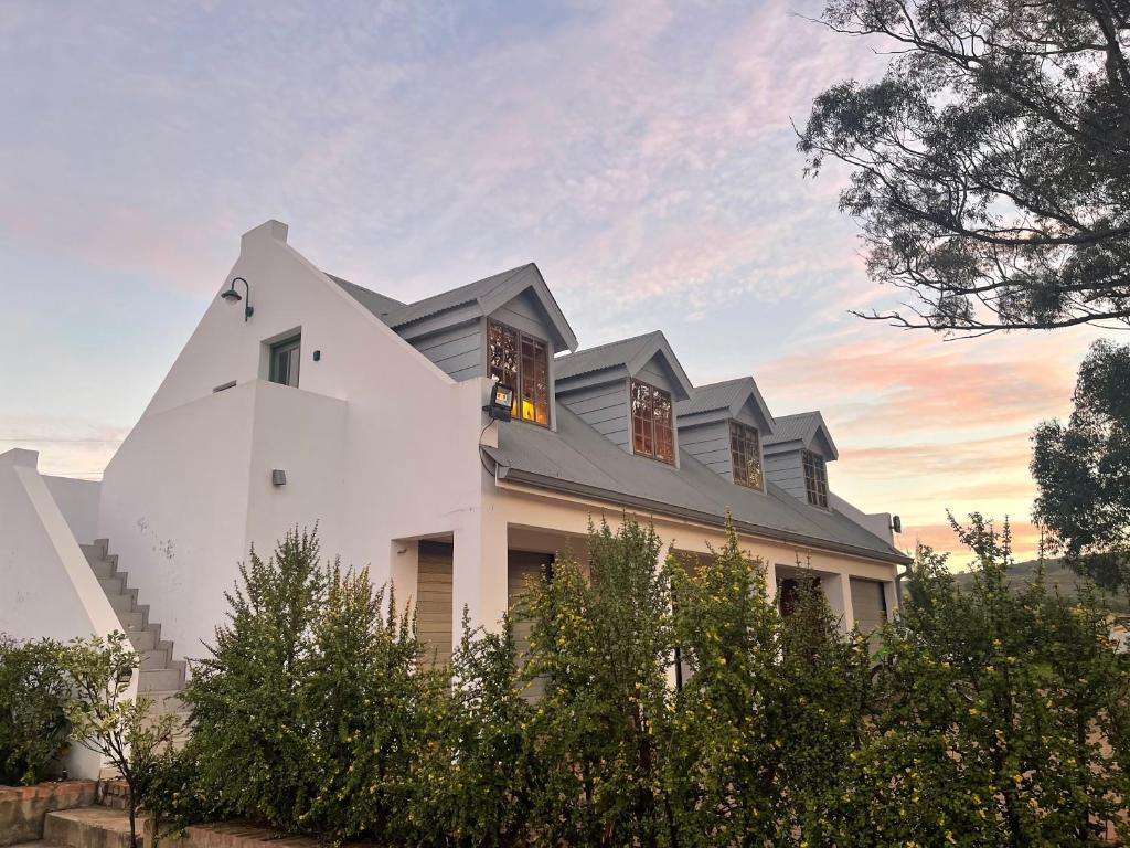 a white house with a gray roof at Farside Macadamias in Riversdale