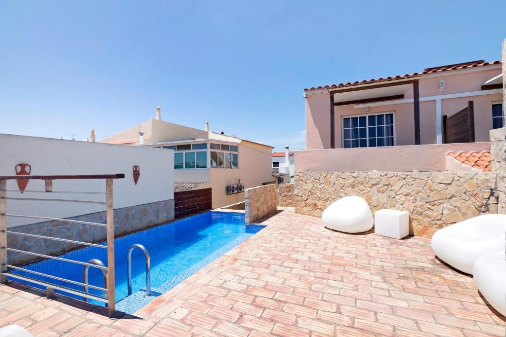 a villa with a swimming pool and a house at South Star Guesthouse in Quelfes