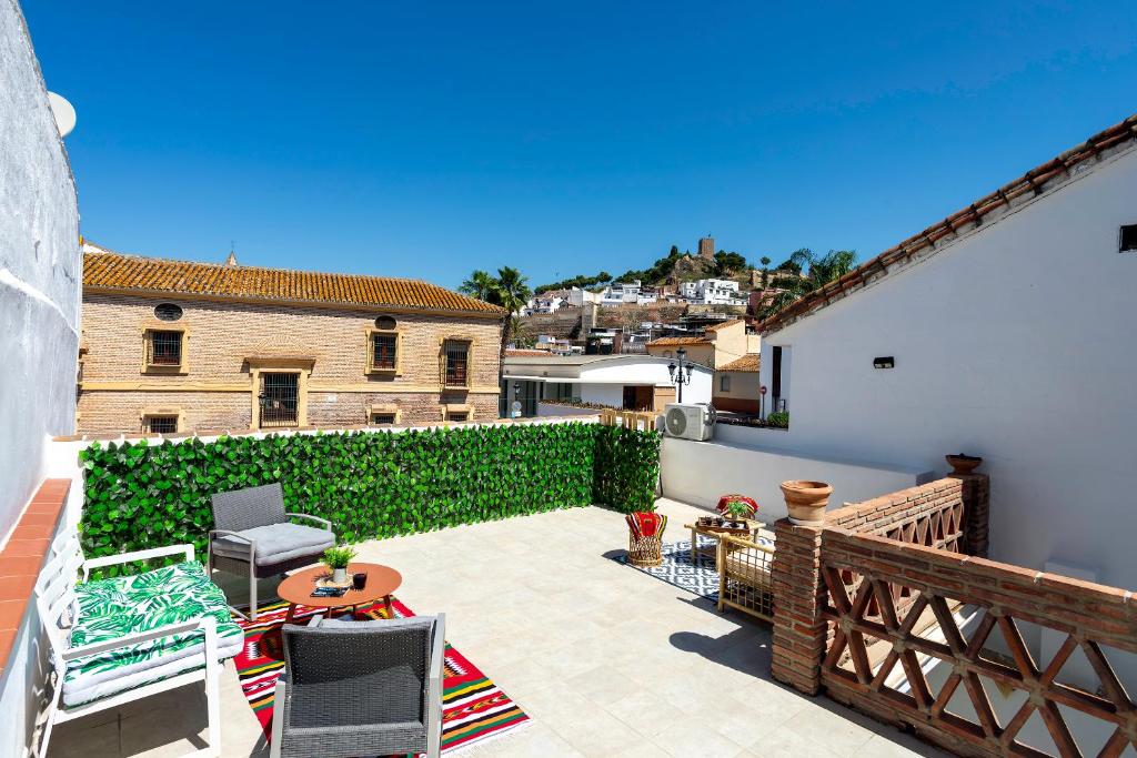 a patio with chairs and a table on a balcony at Sunstay Arroyo House Velez in Vélez-Málaga