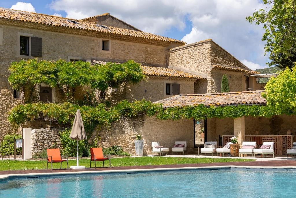a house with a swimming pool in front of a building at Le Mas de Guilles in Lourmarin