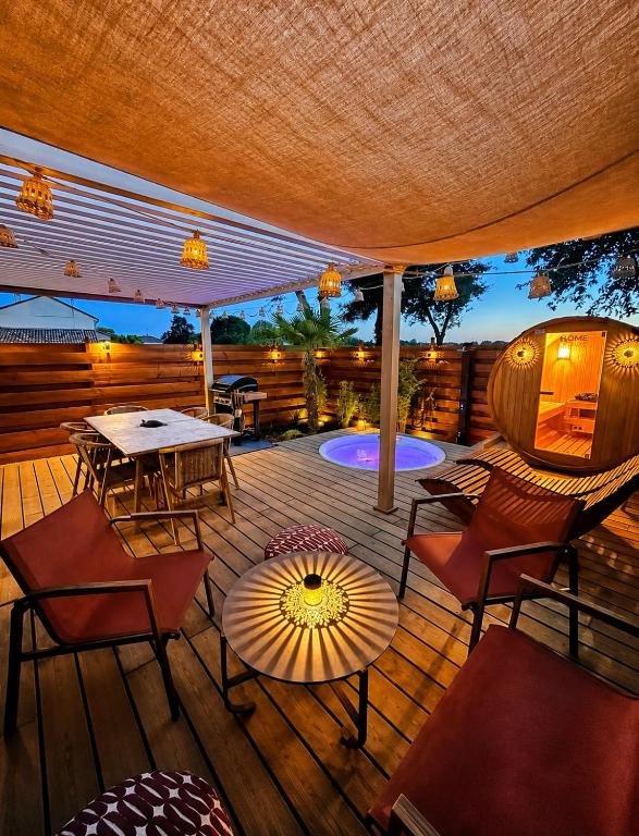 a deck with a table and chairs and an umbrella at Le 25 Bis Spa&Sauna aux portes de Montauban in Lamothe-Capdeville