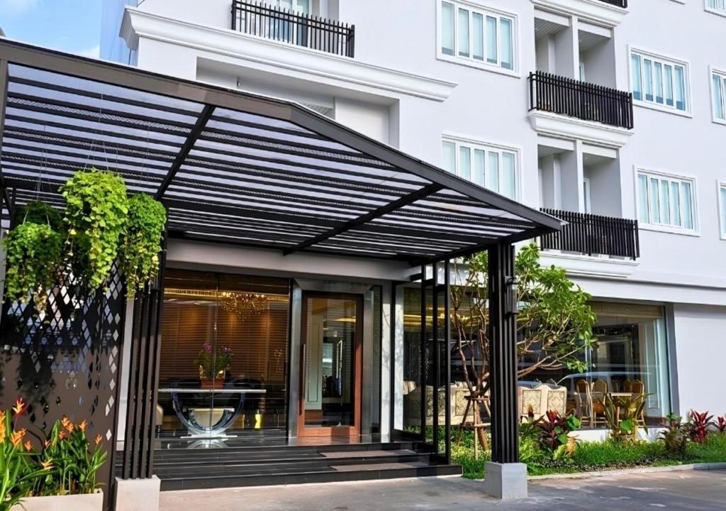 a black pergola in front of a building at Methavalai Residence Hotel in Bangkok