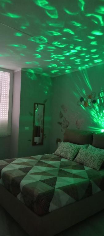 a bedroom with a bed with green lights on the ceiling at Casa vacanza Luna in Eboli